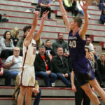 Robbie Baringer makes a three while Anacortes’ Grayson Eaton tries to defend
