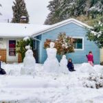 A family making a snow family.  Mountlake Terrace, 2-14-21.