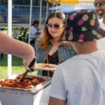 Bonnie serves bacon to customers.  Tour de Terrace pancake breakfast, 7-23-23