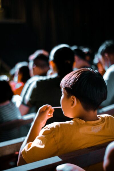 A child snacks on candy in a dark movie theater.