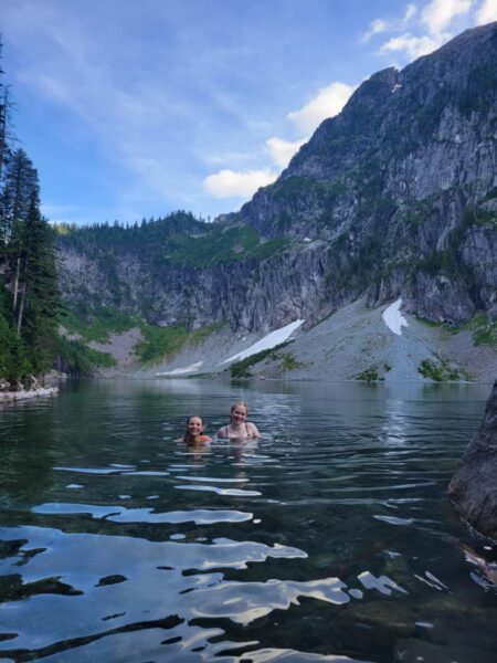 Lake Serene with Alpine views and two teens swimming in the distance.