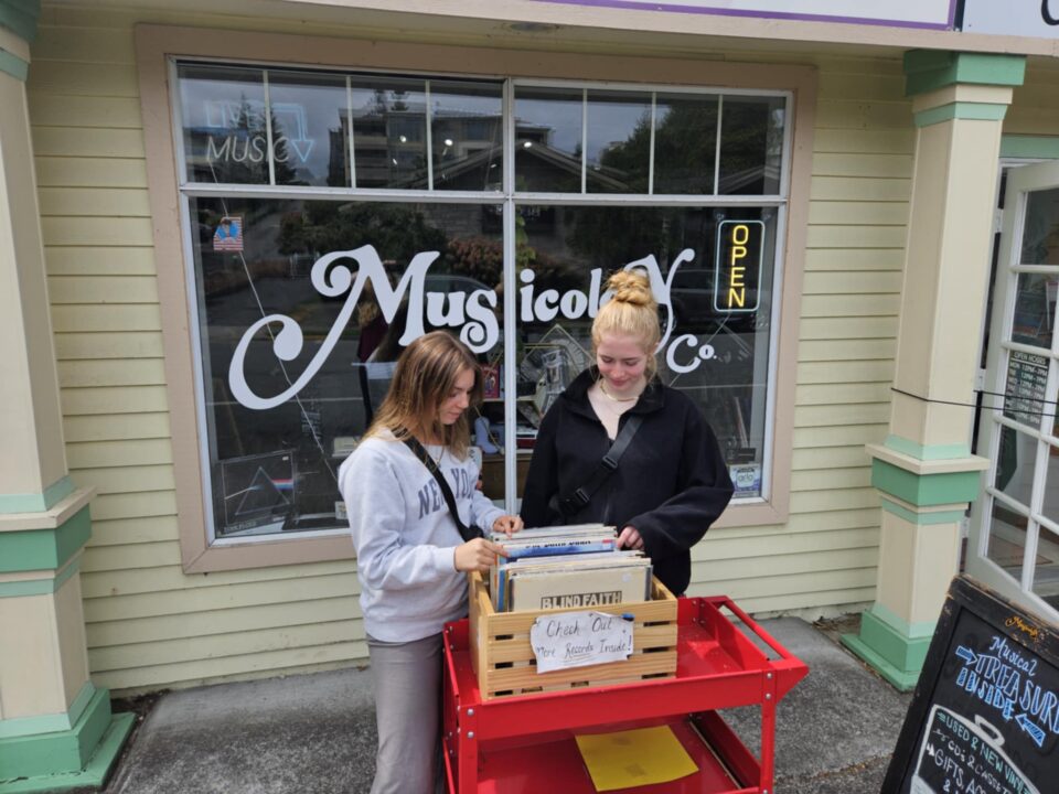 Two girls brows records in front of Musicology in Edmonds.