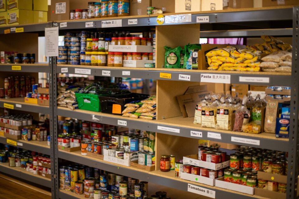 A shelf at a food pantry with a variety of food is shown. 