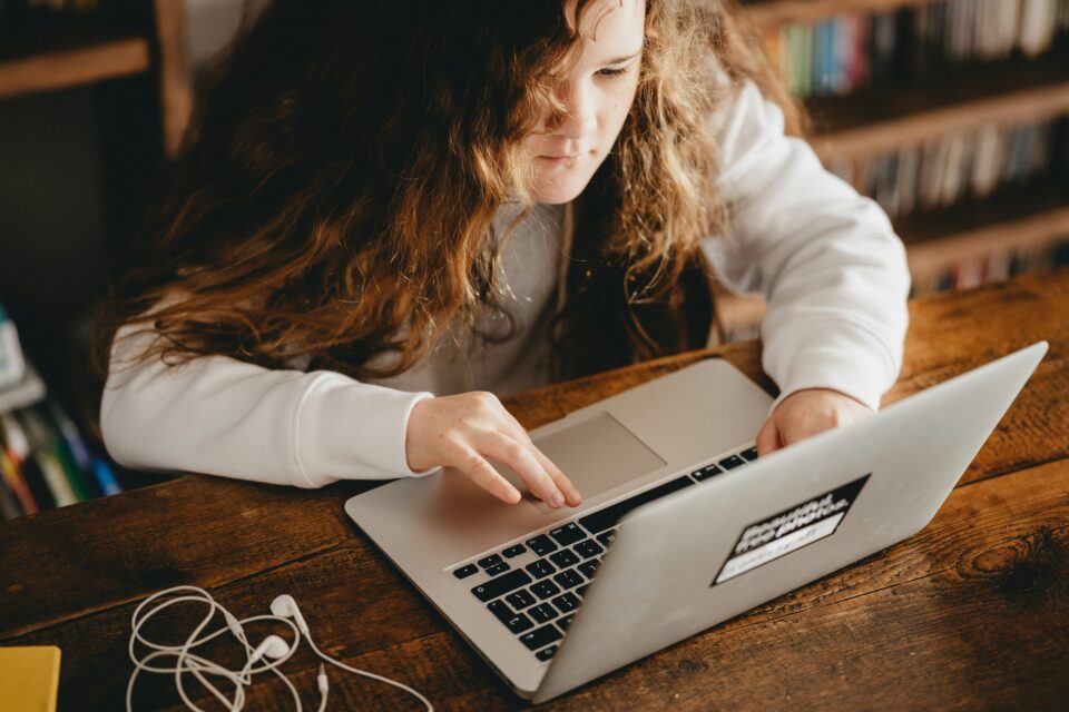 A teen student studies online using a laptop. 