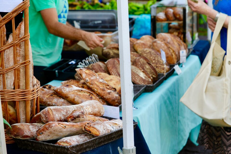Fresh baked bread for sale at an outdoor farmers market booth. 