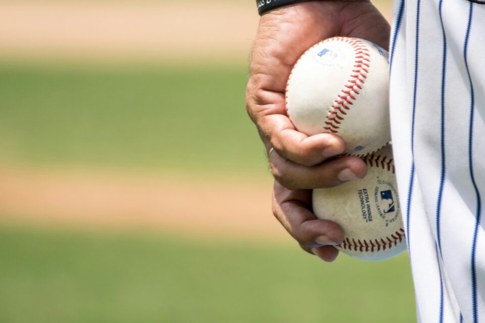 A close-up image of a hand holding a baseball. 