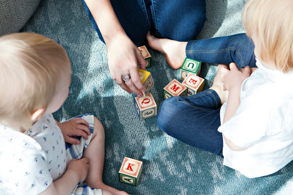 A mother and children play with building blocks. 